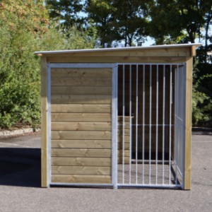 Wall of dog kennel is equipped with wood and mesh