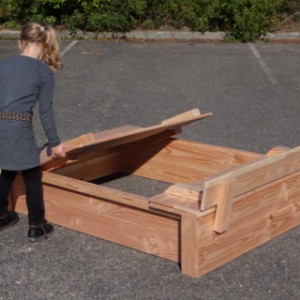 The lid of this sandbox easily folds up into two benches