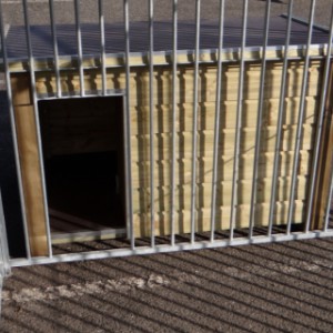 The dog kennel is provided with an opening in the bar panel