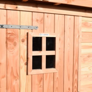 The door of the dog kennel features a window and sturdy metal hinges