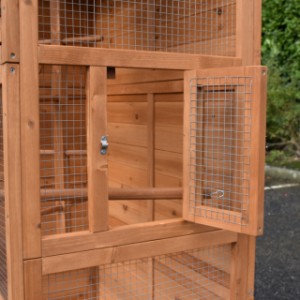 The right side of the wooden aviary is provided with a little opening